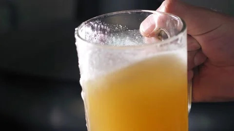 A successful brewer with a beard evaluates freshly brewed beer from a beer tank Stock Footage 152921734