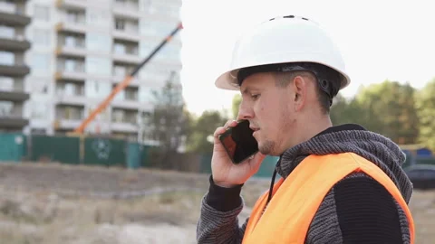 Successful builder engineer, architect in a white helmet, talking on the phone Video stock 117989339