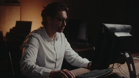 Successful businessman in glasses working on computer in dark office at night 스톡 동영상 342934671