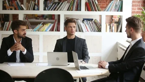 Successful businessman negotiating with business partners at meeting with Stock Footage
