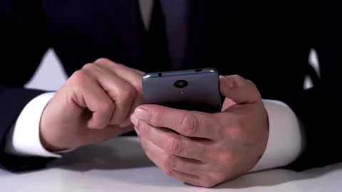 Successful Businessman tapping or scrolling on mobile phone smartphone and Stock Footage 336249688