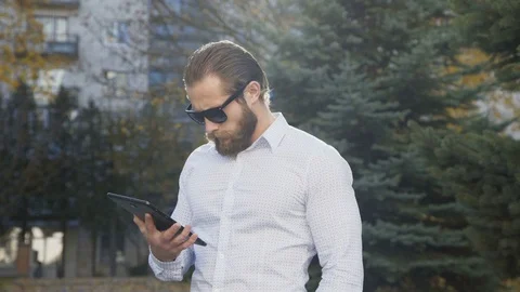 Successful businessman with using tablet computer on a street. 4K Video stock 82930250