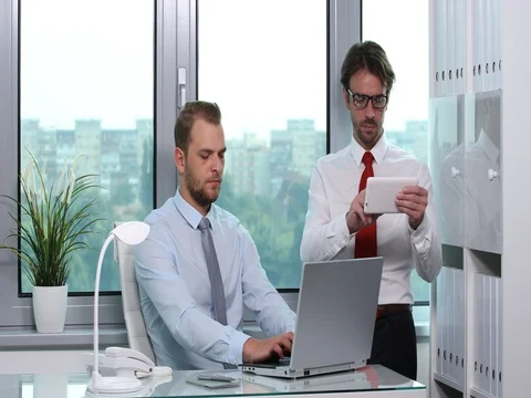 Successful Businessmen Using Digital Tablet and Laptop Office Company Activity Stock Footage 77004417