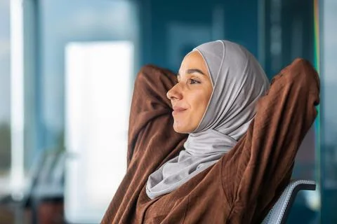 Successful completion of the project, working day. A young Arab woman in a hijab Stock Photos