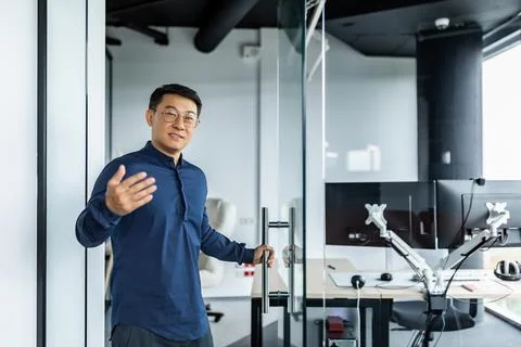 A successful engineer programmer boss invites to his office, an Asian man in a Stock Photos