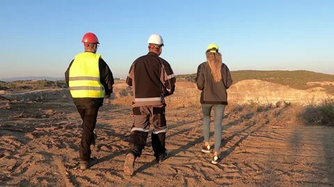 Successful engineer team inspect work progress at sunset in open pit mine con Stock Footage 246568126