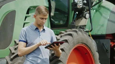 A successful farmer is working in the field. Uses a tablet, stands near the Stock Footage 78630069