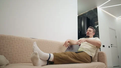 Successful freelancer celebrating project completion on sofa Stock Footage 331529612