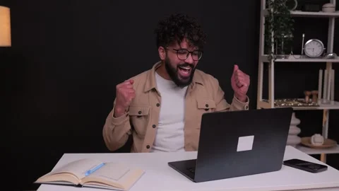 Successful freelancer celebrating victory using laptop at home office Stock Footage 348080832
