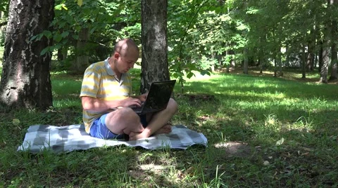 Successful freelancer worker man working with notebook in park. 4K Stock Footage 60740017