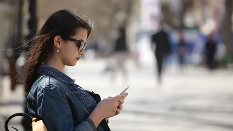 Successful girl surfing the net on her mobile enjoying life on an alley bench Stock-Footage 88409272