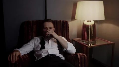 Successful guy drinks alcohol alone. Stock Footage 313097860
