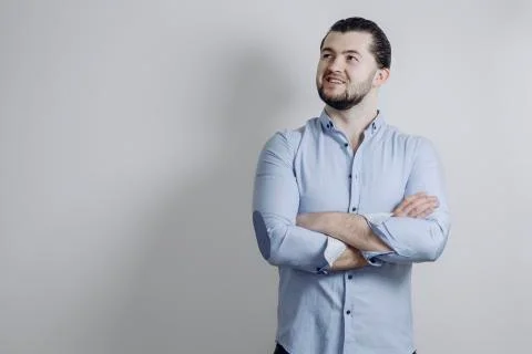 Successful handsome guy with a beard points. Arms crossed and smile Stock-Fotos