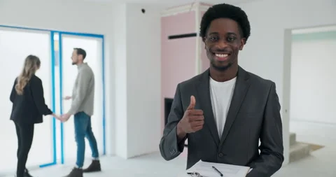 Successful Home Purchase African real estate agent holds the contract in his Stock Footage 277686206