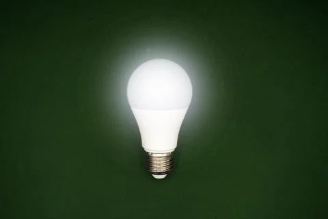 Successful idea concept. Creativity and innovation. Light bulb glows on green Stock Photos