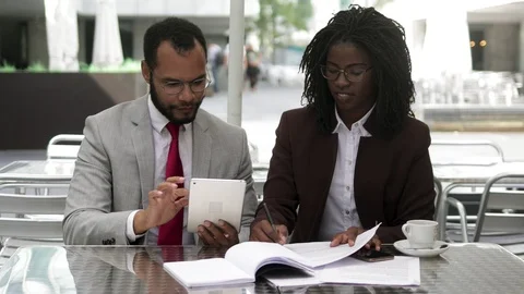 Successful lawyers talking while sitting at table with documents Video stock 114963054