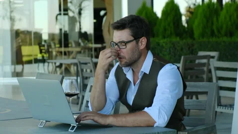 Successful male freelancer sitting at laptop and drinking wine Stock Footage 232552753