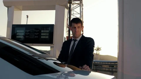 Successful man in a jacket refuel his car at a gas station Stock Footage 128549285
