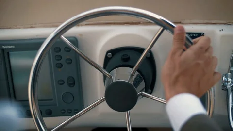 Successful man in a jacket rotates the steering wheel of his yacht. Stock Footage 102662372