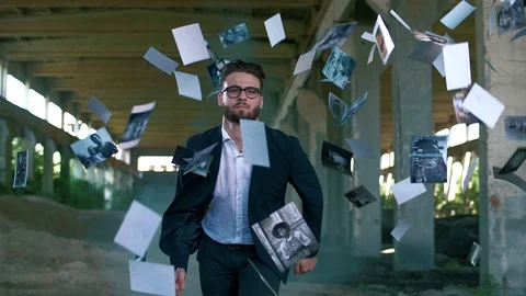 A successful man in a jacket runs in slow motion and old photos fly Stock Footage 128744178