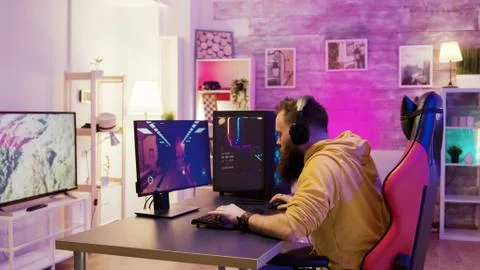 Successful man playing online video games in a room with colorful neons Stock Photos