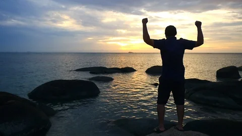 Successful man standing on top of a mountain raising hands. slow motion Stock Footage 101378747