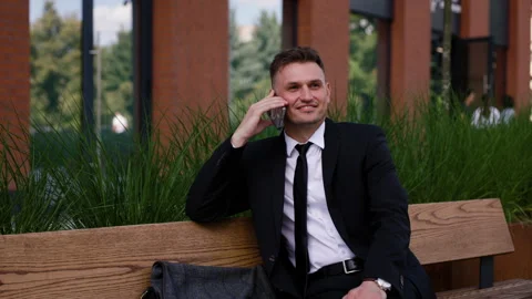 Successful man talking on smartphone outside an office building. Elegant Stock Footage 280613648