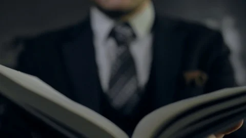 Successful man with a tie closes a cognitive book Stock Footage 89366649