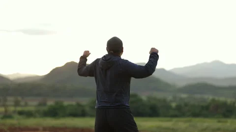 Successful man walking to target and raising arms celebrating at sunset. Stock Footage 158886986