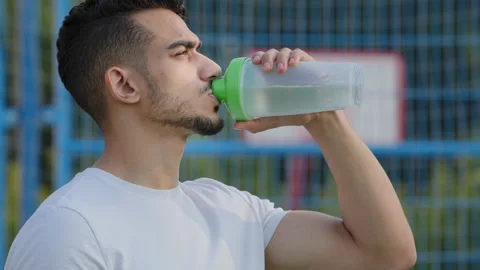 Successful middle eastern indian man athlete latino runner holding drinking from Stock Footage 161914272