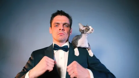 Successful office worker makes dance moves with a cat on his shoulder. Stock Footage 125912277
