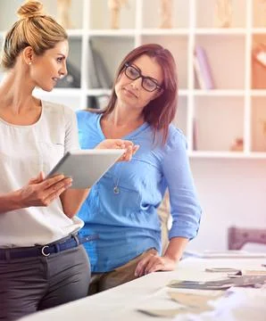 Successful partners problem solve together. two coworkers using a digital tablet Foto stock