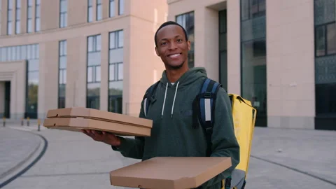 A successful pizza delivery man with boxes looks into the camera Stock Footage 222888856