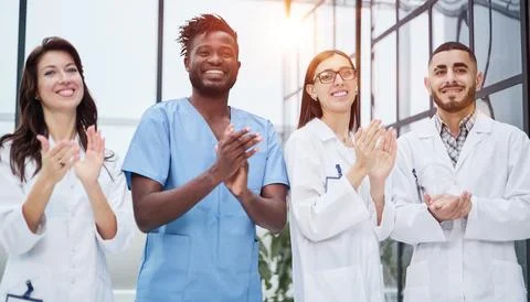 Successful team of different doctors clapping hands Fotos Stock