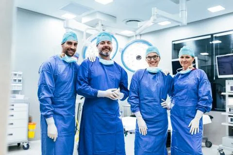 Successful team of surgeon standing in operating room Stock Photos