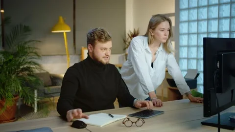 Successful teamwork in modern office of two young motivated professionals using Stock Footage 131550698
