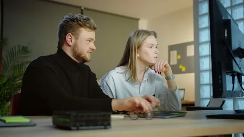 Successful teamwork at modern office workplace of two motivated young Caucasian Stock Footage 131550552