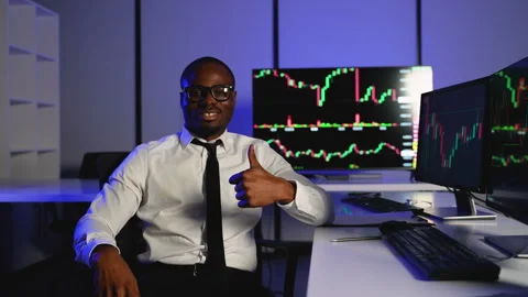 Successful trader giving thumbs up in front of stock charts Stock Footage 305011304