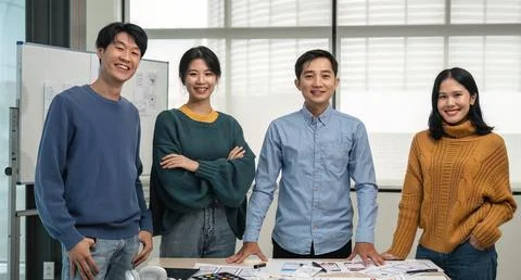 Successful Web developer team. Group of young modern people in casual wear using 写真素材