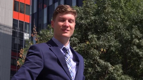 Successful well-dressed manager outside greeting cheerful to camera waving hand Stock Footage