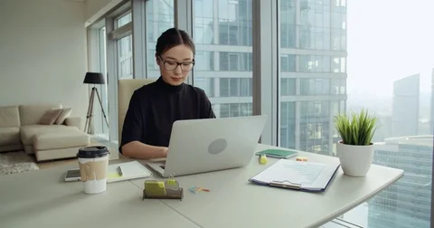 Successful young Asian girl in a modern office skyscraper, the work environment Stock Footage