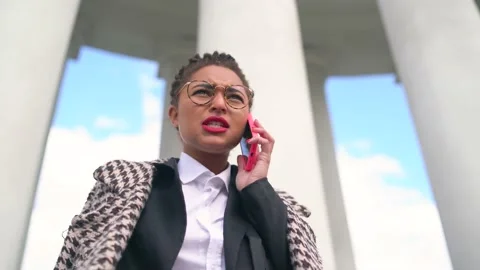 Successful young beautiful dark-skinned woman near business swears on the phone Vidéo 165054530