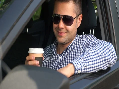 A successful young handsome man drinks coffee in a car Stock Footage 80225208