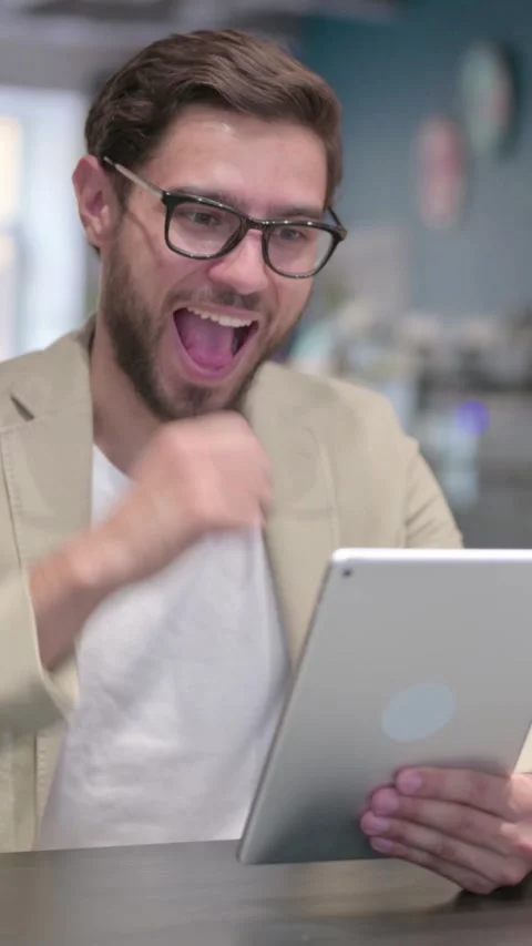 Successful Young Man Celebrating on Tablet, Vertical Video Stock Footage 342005988