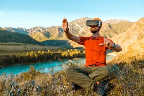 Successful young man using virtual reality goggles tour in mountains on vacation Stock-Fotos