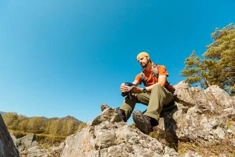Successful young man using virtual reality goggles tour in mountains on vacation Stock Photos