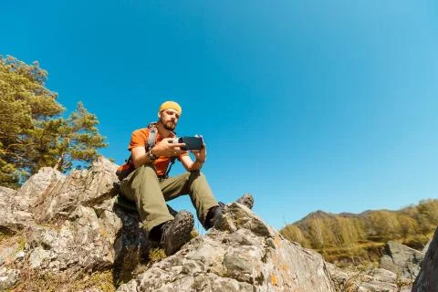 Successful young man using virtual reality goggles tour in mountains on vacation Stock-Fotos