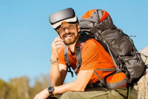 Successful young man, using virtual reality goggles to tour in mountains, on Stock-Fotos