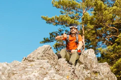 Successful young man, using virtual reality goggles to tour in mountains, on Foto stock