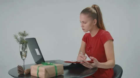 Successfull lady in red uses a computer for work and makes notes in her journal. Stock Footage 157935840